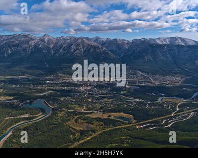 Schöne Luftpanoramasicht auf Bow Valley mit der Stadt Canmore, Alberta, Kanada in den Rocky Mountains mit Rundle Forebay Reservoir und Wäldern. Stockfoto