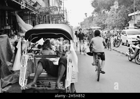 Rikscha-Fahrer ruht auf seiner Rikscha, Malioboro Street, Yogyakarta, Indonesien. Stockfoto