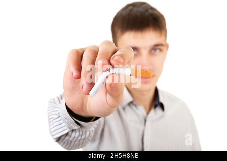 Junger Mann mit zerbrochener Zigarette in einer Nahaufnahme auf dem weißen Hintergrund Stockfoto