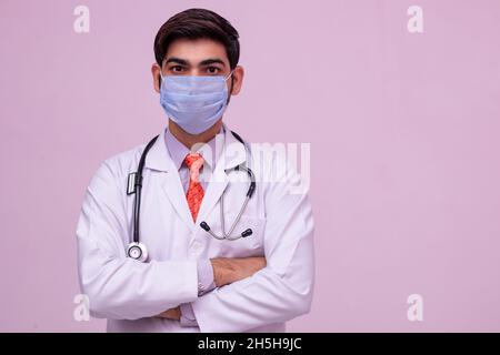 Arzt trägt medizinische Maske auf isoliertem Hintergrund. Stockfoto