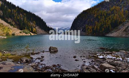 Blick auf den Agnessee in einem Tal, umgeben von Wald mit gelben Lärchen in der Herbstsaison in der Nähe von Lake Louise, Banff National Park, Kanada. Stockfoto