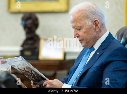 Präsident Joe Biden liest die Zeitung vor einem Telefonat mit dem Vorsitzenden der Repräsentantenminorität Kevin McCarthy, R-Kalifornien, Montag, den 23. August 2021, Im Oval Office des Weißen Hauses. (Offizielles Foto des Weißen Hauses von Adam Schultz) Stockfoto