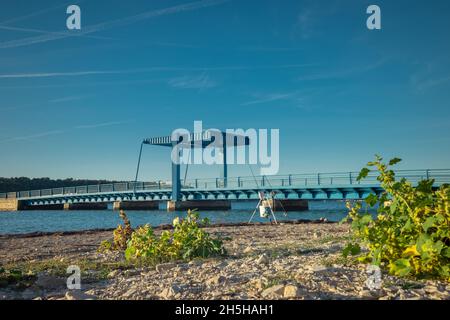 Froschansicht des Tar-Kanals in Kroatien, wo der Fluss Mirna an einem Sommertag in die Adria fließt. Sichtbare blaue Höhenbrücke. Stockfoto