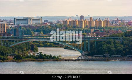 New Yorker Stadtbild mit Henry Hudson Bridge und Spuyten Duyvil Railroad Bridge über den Harlem River, die die Stadtteile Manhattan und Bronx miteinander verbinden. Stockfoto