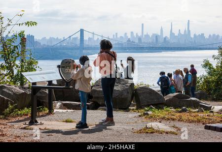 Touristen genießen den Blick auf die George Washington Bridge und die Skyline von Manhattan vom Rockefeller Lookout auf dem Palisades Interstate Parkway. Stockfoto