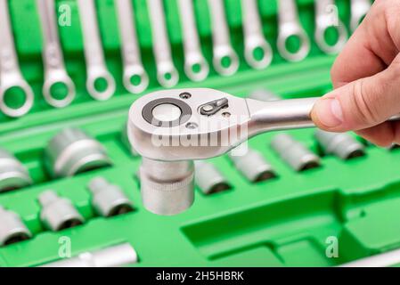 Ein Satz von Werkzeugen für die Reparatur im Autoservice - Mechaniker Hand mit Schraubenschlüssel Instrument, close up. Kunden oder Mitarbeiter im Laden wählen Schraubenschlüssel-Instrumente Stockfoto