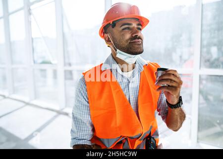 Porträt eines Arbeiters in Arbeitskleidung bei einer Pause Kaffee trinken und sich ausruhen Stockfoto