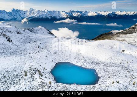 Türkisfarbenes Wasser des Alpensees Rogneda und schneebedeckte Berge im kalten Herbst, rätische Alpen, Lombardei, Italien Stockfoto