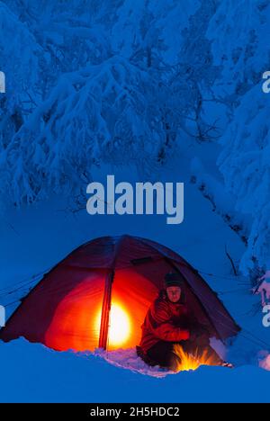 Winter Camping im schneebedeckten Wald Stockfoto