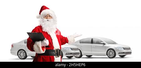 Santa claus zeigt auf neue silberne Autos und hält eine Zwischenablage isoliert auf weißem Hintergrund Stockfoto