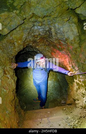 Bergsteiger mit Helm und Stirnlampe im Felstunnel, Freilichtmuseum erster Weltkrieg, Tunnelpfad, Sentiero di Galleria, Lagazuoi, Passo Falzarego Stockfoto