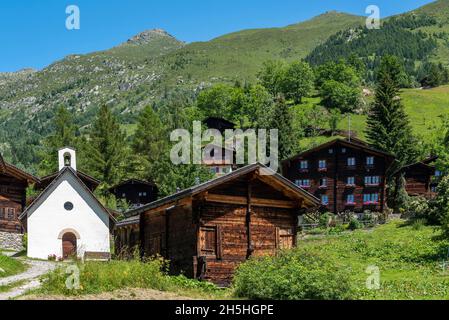 Dorf Eggen mit der Muttergotteskapelle und den Bergen Risihorn und Chummelti im Hintergrund, Bellwald, Wallis, Schweiz Stockfoto