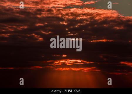Dramatischer Sonnenuntergang hinter Wolken mit Sonnenstrahlen, in Chebel Beau Bassin, Mauritius Stockfoto