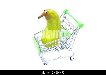 Anthropomorphe Birne mit Stachelaugen in einem kleinen Einkaufswagen isoliert auf Weiß. Stockfoto