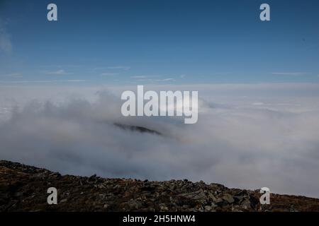 Dicke Wolkenschicht in der Bergspitze | atemberaubende Aussicht auf den Berggipfel über Wolken am sonnigen Tag herrliches Wetter Stockfoto