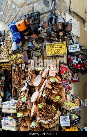 Ein malerisches Geschäft mit Souvenirs, Lebensmitteln und Holzwaren in Borgo Santi Apostoli, einer engen Straße im Stadtzentrum von Florenz, Toskana, Italien. Stockfoto