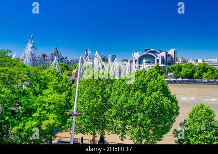 LONDON, GROSSBRITANNIEN - 30. Jun 2015: LONDON, Großbritannien - 29. JUNI 2015: Touristen wandern an einem schönen Sommertag entlang der Themse Stockfoto