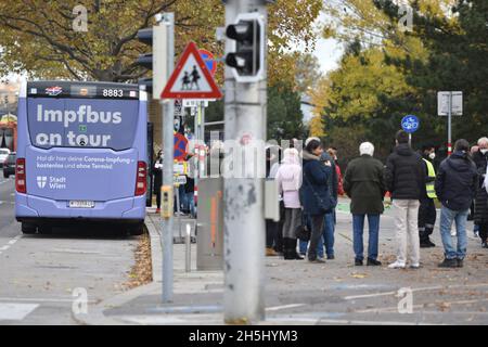 Viele Menschen, die eine Corona-Impfung ahben wollen, vor einem Impfbus der Stadt Wien. Österreich, Europa - viele Menschen, die eine Corona vac haben wollen Stockfoto