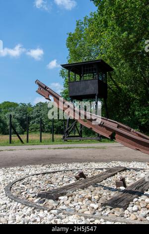 Westerbork, Niederlande-Juli 2021; aus der niedrigen Perspektive gebrochene Eisenbahnstrecke vom Boden gerissen und Wachturm als Denkmal für die Deportation von Juden Stockfoto