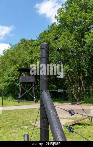 Westerbork, Niederlande-Juli 2021; Blick auf einen der Wachtürme im Monument Transit Camp Westerbork und Stacheldrahtzaun, jetzt Monument Stockfoto