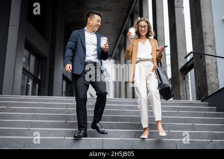 Geschäftsleute gehen und sprechen in Stadt Stockfoto