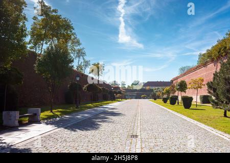 alba-iulia, rumänien - Okt 13, 2019: Innenstraßen der Zitadelle von Alba carolina im Herbst. Laternen und Bänke am Gehweg. Riesige Mauern um den Weg. Stockfoto