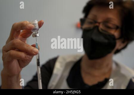 London, Großbritannien. Oktober 2021. Ein Gesundheitsmitarbeiter bereitet sich darauf vor, einer Frau in einem Impfzentrum in London den Pfizer/BioNTech-Booster Covid-19 jab zu verabreichen. (Foto von Dinendra Haria /SOPA Images/Sipa USA) Quelle: SIPA USA/Alamy Live News Stockfoto