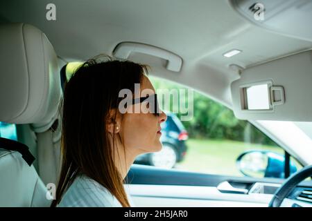 Schöne junge Frau mittleren Alters fahren ernst tragen Sonnenbrille. Marmelade. Routine Stockfoto