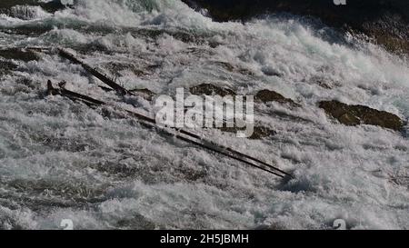 Wunderschöne Aussicht auf die tobenden Bow Falls in der Nähe von Banff, Banff National Park, Alberta, Kanada in den Rocky Mountains mit scharfen Felsen und Treibholz. Stockfoto