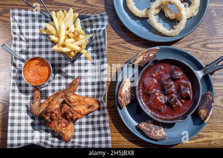 Sheffield UK – 01. Mai 2018: Sticky BBQ Schweinefleisch, gebratenes Huhn, Pommes Frites und Zwiebelringe – amerikanische Grillgerichte vom Fire Pit, West Street Stockfoto