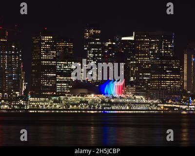 Nachtansicht der Innenstadt von Vancouver, British Columbia, Kanada mit beleuchteten Skyline und Kreuzfahrt Schiff Passagierterminal Gebäude und Wasser Reflexionen. Stockfoto