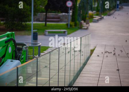 Spatzen und Tauben sitzen auf der Schiene im Rike Park in Tiflis Stockfoto