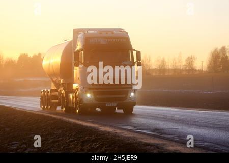 Weißer Volvo FH-Satteltank-LKW fährt im Winter bei Sonnenuntergang durch dichten, sonnenbeschienenen Nebel auf der Straße. Salo, Finnland. 27. Januar 2017. Stockfoto