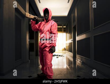 Krimineller Mann in pinker Wachuniform hält die Schrotflinte, während er das Haus raubt Stockfoto