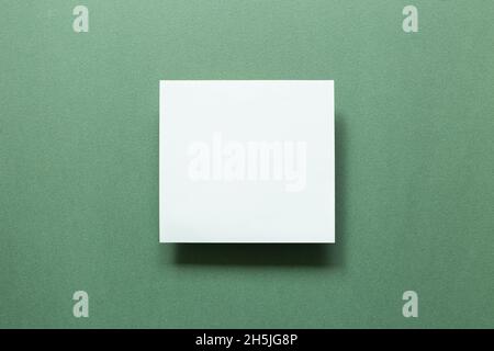Leeres weißes Notizbuch auf grünem Hintergrund. Draufsicht, Kopierbereich Stockfoto