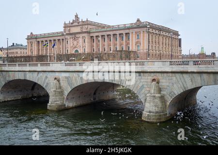 Stockholm, Schweden - 04.15.2017: Gebäude des schwedischen Parlaments Riksdag an einem bewölkten Tag mit einer Brücke vorne. Stockfoto