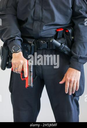 Sachsen, Schneeberg: Am 10. November 2021 demonstriert ein Ausbilder den Umgang mit der Dienstwaffe zu Beginn des Dienstes den Polizeistudenten in ihrem 1. Ausbildungsjahr an der Polizeifachschule. Am selben Tag wurde auf dem Gelände ein moderner Schießstand in Betrieb genommen. In der 6.6 Millionen Euro teuren Anlage können mit Hilfe von Beamern und einem Bildschirm Schießübungen in einem Winkel von 180 Grad durchgeführt werden. Ziel der Schulung ist es, jedem Polizisten und jeder Polizistin zu ermöglichen, den sicheren Umgang mit Waffen zu üben und zu verinnerlichen. Die Schule in Schneeberg trainiert derzeit rund 6 Stockfoto