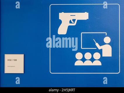 Sachsen, Schneeberg: Am 10. November 2021 weist Ein Schild auf einen Trainingsraum im neuen Hallenschießplatz der Polizeitechnischen Schule hin. Am selben Tag wurde auf dem Gelände eine moderne Schießanlage in Betrieb genommen. In der 6.6 Millionen Euro teuren Anlage können mit Hilfe von Beamern und einem Bildschirm Schießübungen in einem Winkel von 180 Grad durchgeführt werden. Ziel der Schulung ist es, jedem Polizisten und jeder Polizistin zu ermöglichen, den sicheren Umgang mit Waffen zu üben und zu verinnerlichen. Die Schule in Schneeberg bildet derzeit rund 650 Polizeianwärter aus und organisiert auch Fortbildungen. Phot Stockfoto