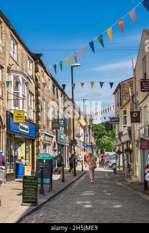 Skipton Stadtzentrum, Blick im Sommer auf Menschen, die in Sheep Street, einer der ältesten Einkaufsstraßen in Skipton, Yorkshire, England, spazieren gehen Stockfoto