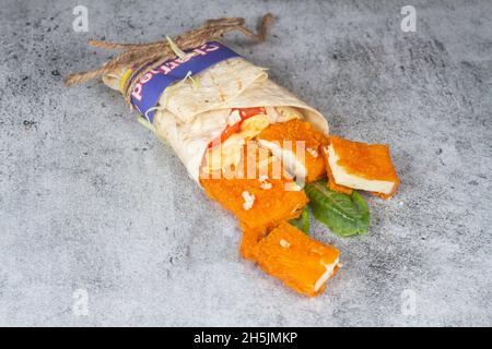 Frische Paneerrolle mit frischen Tomaten, Salat, Käse und Zwiebeln auf hellblauem Hintergrund isoliert. Seite view.selective Fokus Stockfoto