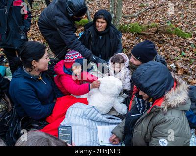 Narewka, Polen. November 2021. Die Kinder wurden beim Spielen mit einem Spielzeug der Organisation Grupa Granica gesehen.Eine siebzehnköpfige Flüchtlingsfamilie, darunter neun Kinder aus Dohuk, Irak, verbrachte siebzehn Tage in einem Wald an der polnischen Grenze in Weißrussland und wurde achtmal zurückgedrängt. Verzweifelt mit einem sieben Monate alten Baby und einer älteren Frau mit Beinproblemen beschlossen sie, Aktivisten um Hilfe zu bitten. Kredit: SOPA Images Limited/Alamy Live Nachrichten Stockfoto