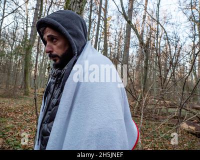 Narewka, Polen. November 2021. Ein junger Mann aus Dohuk, Irakisch-Kurdistan, in einem Wald gesehen.Eine siebzehnköpfige Flüchtlingsfamilie, darunter neun Kinder aus Dohuk, Irak, verbrachte siebzehn Tage in einem Wald an der polnischen Grenze von Belarus und wurde achtmal zurückgedrängt. Verzweifelt mit einem sieben Monate alten Baby und einer älteren Frau mit Beinproblemen beschlossen sie, Aktivisten um Hilfe zu bitten. Kredit: SOPA Images Limited/Alamy Live Nachrichten Stockfoto