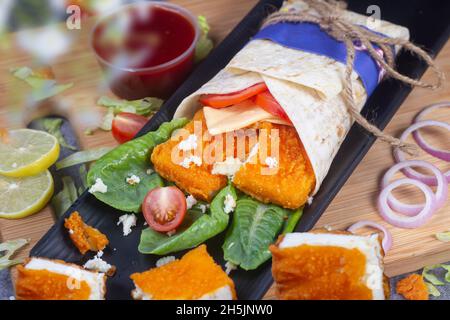 Frische Paneerrolle mit frischen Tomaten, Salat, Käse und Zwiebeln auf hellblauem Hintergrund isoliert. Seite view.selective Fokus Stockfoto