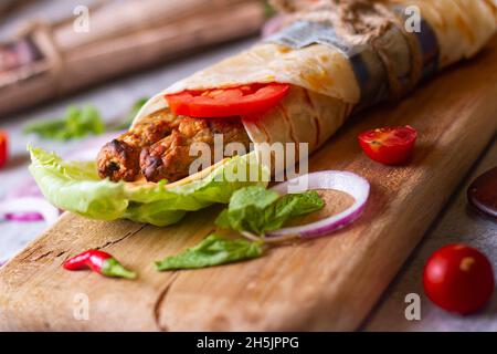 Frisches Hühnerfleisch mit frischen Tomaten, Salat, Käse und Zwiebeln auf hellblauem Hintergrund isoliert. Seite view.selective Fokus Stockfoto