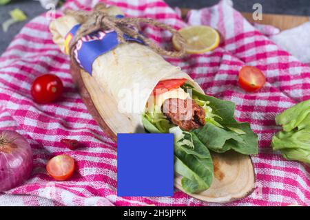 Frisches Hühnerfleisch mit frischen Tomaten, Salat, Käse und Zwiebeln auf hellblauem Hintergrund isoliert. Seite view.selective Fokus Stockfoto