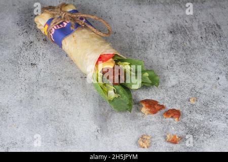 Frisches Hühnerfleisch mit frischen Tomaten, Salat, Käse und Zwiebeln auf hellblauem Hintergrund isoliert. Seite view.selective Fokus Stockfoto