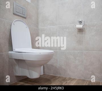 Moderne Toilette mit Wandmontage, kombiniertes Badezimmer. Keramikfliesen an der Wand. Platz für Text kopieren Stockfoto