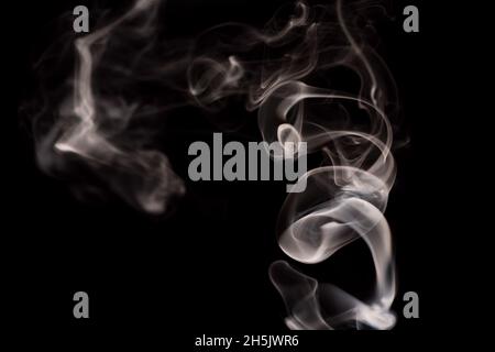 Abstrakte Rauchbewegung auf dunklem Hintergrund. Konzept des alternativen Nikotinrauchens. Verschwommenes Bild warmer, getönter Rauch. Elektronische Zigarette. Verdampfer. Weichfokus. Streaming. Stockfoto