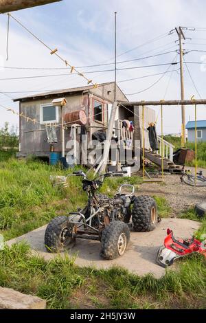 Ein zerlegter 4-Rad mit zwei Platten Reifen sitzt auf einer Sperrholzplatte vor einem Haus in Mountain Village, Western Alaska, USA Stockfoto