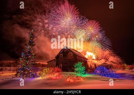 Während des Yukon Sourdough Rendezvous Festivals in Whitehorse, Yukon, Kanada, explodiert ein Feuerwerk über einer Hütte Stockfoto